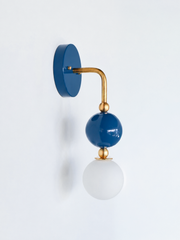 A closer look at the denim blue and brass Ida sconce, with the glass orb and brass ball accents set against a matching denim backplate. Works for colorful bathroom vanity lighting, powder room sconces, or coastal traditional decor, a strong option for anyone building a Southern interiors or coastal bathroom instead of defaulting to white and chrome.