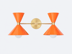 Bold orange and brass two light oversized bathroom wall sconce. Mid-century modern style wall sconce that is perfect for bold, colorful bathrooms, kids bathrooms, eclectic design, and more.  Fun way to introduce color to a bathroom or match wallpaper. Helps create a statement bathroom or powder room.