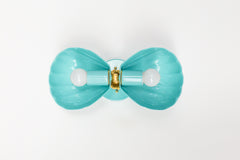 A wide, opened-out view of the poolside turquoise Double Coquille sconce, showing how the two fluted shell shades and brass rosette connect at the center. A helpful reference for seeing the full construction and hardware detail before choosing a coastal or scalloped sconce for a bathroom or powder room.