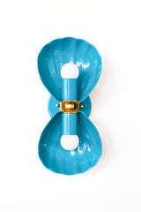 A double wall sconce in a bright, saturated teal, with two fluted shell shades meeting at an ornate brass floral rosette. This punchier teal reads more confident and maximalist than a soft poolside or hydrangea blue, a strong pick for a bold coastal traditional bathroom, an English coastal entry, or a fully eclectic space that wants a real jewel-tone moment. Layer it into a grandmillennial room full of pattern, or let it stand alone as one graphic, high-shine detail against a plain wall.