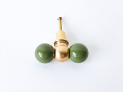 A double-ball cabinet knob pairing two glossy olive green spheres with a smaller polished brass ball at the center, giving it more presence than a standard single knob. A good option for anyone wanting to bring color into kitchen or bathroom cabinetry without a full paint job, one hardware swap at a time.