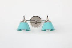 Small double vanity sconce in chrome with Poolside blue powder coated cone shades, designed for installation above a bathroom mirror or over each mirror in a double sink bathroom, a colorful bathroom wall light for maximalist interiors, eclectic home decor, and modern retro bathroom design.