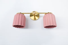 Double Marcella wall sconce with two ribbed glazed pastel pink ceramic shades and a warm brass backplate, a sculptural Art Deco inspired ceramic bathroom vanity light handmade in the USA, perfect for grandmillennial and chinoiserie interiors and color drenched powder rooms