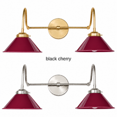 A burgundy red two-light gooseneck wall sconce with glossy cone shades, shown in Black Cherry with brass or nickel hardware. It has two curved gooseneck arms joined by a straight crossbar at a round backplate, so it sits wide like a vanity light. Hang it over a bathroom mirror, above a kitchen sink, or over a home bar. Deep red pairs well with dark green walls, wood paneling, and warm brass, so it suits vintage, grandmillennial, and moody traditional rooms.