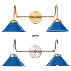 A denim blue two-light gooseneck wall sconce with glossy cone shades, shown in Denim with brass or nickel hardware. It has two curved gooseneck arms joined by a straight crossbar at a round backplate, so it sits wide like a vanity light. Hang it over a bathroom mirror, above a kitchen sink, or down a long hallway. Denim blue sits well with red or rust accents, gingham, and warm oak floors, so it suits farmhouse, Americana, and relaxed modern rooms.