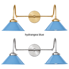 A powder blue two-light gooseneck wall sconce with glossy cone shades, shown in Hydrangea Blue with brass or nickel hardware. It has two curved gooseneck arms joined by a straight crossbar at a round backplate, so it sits wide like a vanity light. Hang it over a bathroom mirror, above a kitchen window, or in a powder room. Powder blue pairs well with chinoiserie, blue and white porcelain, and floral wallpaper, so it suits grandmillennial, French country, and traditional rooms.