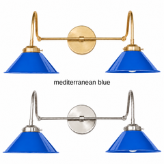 A cobalt blue two-light gooseneck wall sconce with glossy cone shades, shown in Mediterranean Blue with brass or nickel hardware. It has two curved gooseneck arms joined by a straight crossbar at a round backplate, so it sits wide like a vanity light. Hang it over a bathroom mirror, above a kitchen sink, or over open shelving. Cobalt looks sharp with white plaster, patterned cement tile, and terracotta, so it suits Mediterranean, Spanish revival, and bold colorful kitchens.