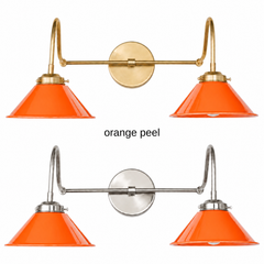 A bright orange two-light gooseneck wall sconce with glossy cone shades, shown in Orange Peel with brass or nickel hardware. It has two curved gooseneck arms joined by a straight crossbar at a round backplate, so it sits wide like a vanity light. Hang it over a bathroom mirror, a kitchen window, or a coffee bar. Orange pops against pink or blue walls, white tile, and walnut, so it suits mid century modern kitchens, 70s inspired bathrooms, and colorful eclectic rooms.