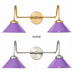 A purple two-light gooseneck wall sconce with glossy cone shades, shown in Orchid with brass or nickel hardware. It has two curved gooseneck arms joined by a straight crossbar at a round backplate, so it sits wide like a vanity light. Hang it over a bathroom mirror, above a kitchen sink, or in a powder room. Orchid looks great with chartreuse or marigold accents, pink walls, and brass, so it suits maximalist, eclectic, and playful bathroom decor.
