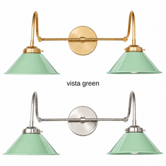 A vista green two-light gooseneck wall sconce with glossy cone shades, shown in Vista Green with brass or nickel hardware. It has two curved gooseneck arms joined by a straight crossbar at a round backplate, so it sits wide like a vanity light. Hang it over a bathroom mirror, above a kitchen window, or over a coffee bar. Soft mint looks good with pink tile, white cabinets, and warm brass, so it suits 1950s vintage, jadeite kitchen, and pastel cottage rooms.