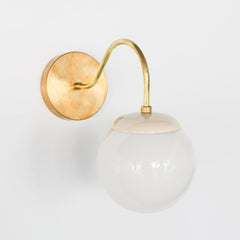 Brass and cream Mid Century modern style wall sconce with white globe shade
