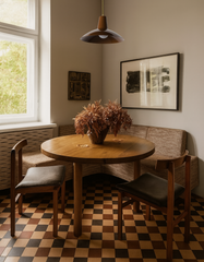 Bruxelles Pendant Light in rich fudge brown with brass accents, styled over a round wood dining table in a monochromatic neutral dining nook with checkered brown tile floor, mid-century modern chairs, and earthy minimalist decor. Handmade pendant lighting from Sazerac Stitches — perfect for modern kitchens, dining rooms, and Scandinavian-inspired interiors with warm brown tones and natural textures.