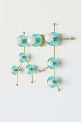 Front view studio image of the Gemini One sconce in Poolside and Brass, designed to look like the Gemini astrological constellation. Soft turquoise blue discs, white globe bulbs, and brass rods create a modern star map effect that reads as both lighting and wall art. This pastel constellation fixture is ideal for buyers looking for a colorful wall sconce, zodiac lighting, astrology decor, mid century modern wall light, nursery lighting, playroom lighting, dopamine decor, or a unique statement sconce for an 
