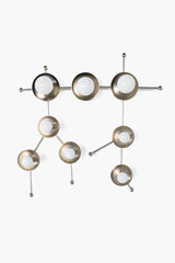 The Gemini One Sconce in Chrome is a sculptural wall light inspired by the Gemini star constellation, combining celestial influence with a clean modern silhouette. This studio product photo highlights the polished chrome finish, branching linear form, and globe bulbs arranged in a constellation-like composition that feels both playful and architectural. Its design makes it a strong fit for modern interiors, contemporary spaces, kids’ rooms, nurseries, playrooms, bedrooms, and statement hallways. Great searc