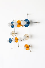 Studio photo of the Gemini One sconce in mustard yellow, denim blue, cream, and chrome, arranged in the shape of the Gemini star constellation. White globe bulbs sit inside colorful circular discs connected by polished chrome rods, giving the fixture a sculptural, celestial look. This zodiac-inspired wall light feels playful, artistic, and modern, perfect for maximalist interiors, kids rooms, creative studios, colorful powder rooms, astrology lovers, and eclectic homes that use lighting as wall art.