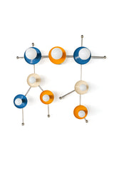The Gemini One in mustard, denim blue, cream, and chrome turns the Gemini constellation into a bold decorative wall sconce. The mix of warm yellow, deep blue, soft cream, shiny chrome, and white globe bulbs gives the fixture a graphic, mid-century modern feel with a quirky celestial twist. This statement light works beautifully in colorful bedrooms, playrooms, nurseries, art-filled hallways, and interiors designed for people who love zodiac decor, sculptural lighting, and personality-driven design.