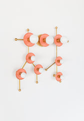 This peach and brass Gemini One fixture turns the Gemini constellation into colorful wall art with a soft pastel palette and bold modern shape. The peach star-like discs and white globe bulbs are connected by brass rods, giving the piece a mid century modern, astrology-inspired, and slightly pop art feel. It works beautifully in playful bathrooms, whimsical bedrooms, colorful playrooms, and interiors designed for zodiac lovers, maximalists, and people who want lighting that feels like sculpture.