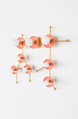 The Gemini One in peach and brass is a pastel zodiac-inspired wall sconce shaped after the Gemini star constellation. Peach circular discs, warm brass arms, and white globe bulbs create a playful sculptural light that feels artistic, colorful, and totally unexpected. This celestial statement fixture is perfect for maximalist interiors, kids’ rooms, nurseries, creative studios, powder rooms, and eclectic homes that need a soft pop of color with a polished brass finish.