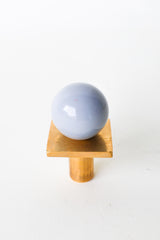 Modern grey and brass square gumball knob for cabinets, dressers, and furniture. Adds a soft neutral touch to bathrooms, nurseries, or kitchens. Unique ball-shaped cabinet hardware brings subtle color, whimsy, and style to any room. Ideal for midcentury or minimalist interiors.