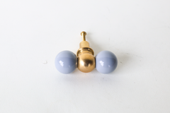 A double-ball cabinet knob pairing two glossy slate grey spheres with a polished brass ball at the center, a quieter option than the brand's bolder colorways. A good pick for anyone wanting a little shape and personality on their cabinetry without going fully saturated, on a bathroom vanity, dresser, or kitchen that calls for something more restrained.