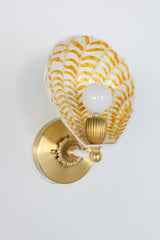 Art Deco-inspired Coquille Sconce with hand-painted brushstroke design in gold over creamy powder-coated steel, shown lit with vintage-style brass hardware; one-of-a-kind wall sconce made in New Orleans