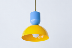 Blue and yellow is the happiest color pairing there is, and this two-tone Taeuber pendant bottles it. The sculptural silhouette pairs a glossy hydrangea blue cup top with a sunny yellow dome, joined by a warm brass stem, for a fresh, cheerful, high-energy look. It reads playful and very custom, the kind of statement lighting that turns a kitchen island, breakfast nook, or kids' space into a real focal point. Hang one for a burst of color or a row for maximum joy. A great choice for a colorful, collected hom