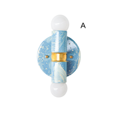Hydrangea, Cream, and Gold hand-marbled Small Thalia Sconce shown as a close-up product photo on a white background. This petite two-light wall sconce features soft blue marbling, creamy white swirls, brass hardware, and round white globe bulbs for a playful but polished look. A great fit for coastal bathrooms, kids bathrooms, powder rooms, blue and white interiors, grandmillennial decor, cottage style spaces, and small rooms that need colorful decorative lighting.