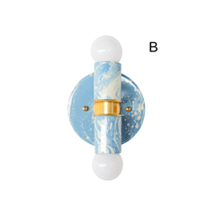 Small Thalia Sconce in a hand-marbled Hydrangea blue, Cream, and Gold finish, photographed vertically to show the one-of-a-kind marbled pattern across the backplate and cylindrical socket covers. The soft blue and cream colorway gives this compact wall light a fresh coastal feel while the brass center detail adds warmth. Ideal for bathroom vanity lighting, kids bath sconces, powder rooms, beach house decor, cottage bathrooms, and blue and white grandmillennial spaces.