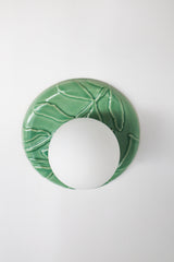 Top view of jade green ceramic leafy backplate with frosted globe, glossy celadon-style glaze, botanical green ceramic wall sconce