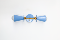 This hydrangea blue vanity sconce brings a gentle, soft color into a nursery, coastal bedroom, or Southern traditional space, and works just as well flanking a bathroom mirror in pairs. The double cone shape and brass ball hardware keep the silhouette clean and symmetrical, letting the soft blue carry the room without feeling too sweet. A good choice for anyone wanting color without too much intensity.
