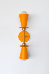 This mustard and brass vanity sconce is built to bring warmth into a room, whether that's flanking a bathroom mirror, anchoring an entryway, or adding color to a hallway. The double cone shape and brass ball hardware keep it feeling considered rather than trendy, so it holds up in a traditional, cottage, or grandmillennial-leaning space. A good pick for anyone who wants their lighting to read as a real design choice.
