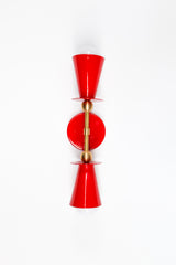 This vertical bath bar sconce is built to flank a bathroom mirror in pairs, with two red cone shades and brass ball hardware giving it a mid-century, Art Deco-adjacent shape. It works as vanity lighting in a powder room, as hallway sconces, or even bedside in place of a table lamp. Bold color, symmetrical shape, made to actually get noticed instead of disappearing into the wall.