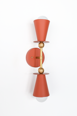 This vertical bath bar sconce is built to flank a bathroom mirror in pairs, with two terra cotta cone shades and brass ball hardware giving it a mid-century, Art Deco-adjacent shape. The warm, earthy tone fits naturally into a Southern or Mediterranean-leaning space, a sunroom, or an entryway, and works just as well as vanity lighting in a powder room. Symmetrical shape, grounded color, made to actually get noticed instead of disappearing into the wall.
