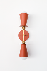 This terra cotta vanity sconce brings an earthy, sun-warmed tone to an entryway, sunroom, or Mediterranean-leaning bedroom, and works equally well flanking a bathroom mirror in pairs. The double cone shape and brass ball hardware keep the silhouette clean and symmetrical, letting the grounded color carry the room. A strong pick for anyone building a warm, Southern-inspired palette with real depth.
