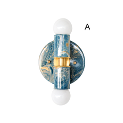 Thalia two-light sconce in lagoon, cream, and gold marbled finish, shown front-facing on a white background with white globe bulbs and a brass center band. Glossy swirled marbling creates a one-of-a-kind look, combining modern sculptural lighting with art-object color. Compact wall sconce or flush mount ceiling light for powder rooms, hallways, entryways, bedside lighting, and playful modern interiors.