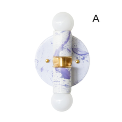 This Thalia sconce features a dreamy white and lavender marbled finish with polished brass hardware and round white bulbs, creating a soft, sculptural look that feels both pretty and artful. The pastel marbling keeps it light and feminine, while the bold pattern adds personality for maximalist and eclectic interiors. Ideal for bathroom vanity lighting, a colorful powder room, a whimsical bedroom, or a boutique hotel bath. Great for customers searching for pastel wall sconces, lavender lighting, handmade sco