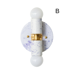 Shown in a clean product photo, this handmade Thalia wall sconce features a white and lavender marbled finish with subtle movement, warm brass hardware, and globe bulbs at both ends. The color palette is soft and romantic, making it a beautiful choice for a feminine powder room, a pretty kids bathroom, or a bedroom that leans pastel and playful. The marbling adds a one-of-a-kind artistic quality that suits maximalist decor, eclectic styling, and interiors that mix sweetness with bold personality.