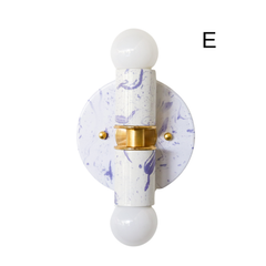 Shown in a clean product photo, this Thalia wall sconce features white and lavender marbling, globe bulbs, and warm brass detailing. Its compact size makes it ideal for bathrooms and small spaces, especially where you want a pretty pop of color without overwhelming the room. This style works well in kids spaces, playful guest baths, and feminine interiors, and it pairs especially nicely with floral wallpaper, pastel tile, lacquered furniture, or chinoiserie-inspired decorating.
