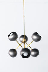 Steel and brass industrial inspired metal chandelier with globe shades.  Made in New Orleans. Unique lighting design