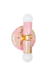 Side-angle view of the hand-marbled Thalia sconce in blush pink, cream, and gold, showing the fixture’s depth and sculptural profile. The round backplate, brass collar detail, and vertical center column create a clean, architectural silhouette, while the marbled finish adds a one-of-a-kind, painterly look. This compact wall light is a perfect choice for bathrooms and powder rooms, especially beside a mirror or in a tight hallway where you want a small statement piece. A great fit for dopamine decor, eclecti