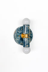 Side profile of the Thalia Sconce in lagoon blue, cream, and gold marbled finish with brass center detail and white globe bulbs. Shows compact depth and sculptural layered silhouette, a modern wall sconce or flush mount ceiling light suited to narrow hallways, powder rooms, and entryways.