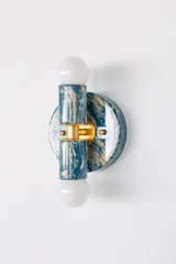 Thalia Sconce shown from an angled view highlighting the round wall plate, brass center band, and glossy lagoon, cream, and gold marbled discs. Two-light wall sconce or flush mount ceiling light designed for compact spaces and high-impact modern color.