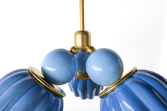 A close-up look at the Marcella Small Chandelier’s construction, the smooth hydrangea blue glass balls, brass trim rings, and the fluted top edge of each sky blue cone shade all visible up close. The hand-finished detail here is what separates this from a mass-produced pendant, good for anyone who wants to see the quality of the hardware and glasswork before choosing it for a nursery or powder room.