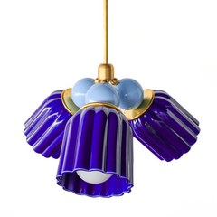 A small chandelier with deep, glossy cobalt fluted ceramic cone shades, paired with softer hydrangea blue powder-coated steel balls and brass hardware. The tonal shift within one blue family gives this real depth without needing contrast from another color. A bold choice for a coastal traditional entry, a Chinoiserie-leaning dining room, or any space that wants a true, confident blue instead of something pastel or muted.