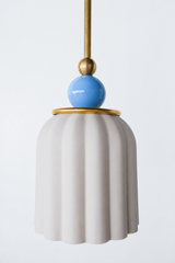 unglazed cream porcelain shade with blue and brass accents. the pendant shade has a ribbed shape and unglazed. Includes a powdercoated ball and brass hardware accents. Modern and handmade in New Orleans by Sazerac Stitches.