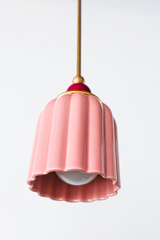 soft pastel Chinoiserie Pink ceramic ceiling pendant with brass hardware and a black cherry powdercoated ball. Inspired by art deco glass with updated modern accents. This beautiful pendant light adds color and shape to any space. 