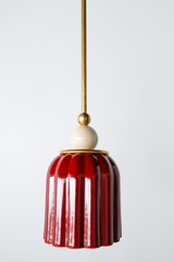 jasper red art deco pendant light with ribbed ceramic shade, powdercoated ball, and brass hardware. Beautiful rich red hanging pendant light handmade in new orleans by Sazerac Stitches.