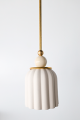 unglazed cream porcelain shade with cream and brass accents. the pendant shade has a ribbed shape and unglazed. Includes a powdercoated ball and brass hardware accents. Modern and handmade in New Orleans by Sazerac Stitches.
