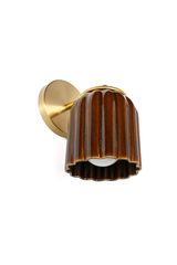 This angle shows how the Marcella Sconce projects off the wall and reveals the globe bulb tucked into the scalloped base of the shade. The brass arm and ring collar hold the streaked amber Chicory Brown glaze in place, giving the whole fixture a sculptural, downward-facing presence.