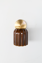 Seen straight on, the Marcella Sconce shows off the depth of its Chicory Brown glaze, streaking naturally down each flute for a look that feels more handmade pottery than manufactured fixture. The brass ring collar and round backplate keep the silhouette clean. A warm, grounded pick for traditional bathrooms and hallways.